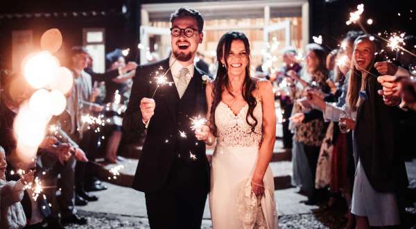 Bride and groom celebrating with fireworks at vaulty manor grounds